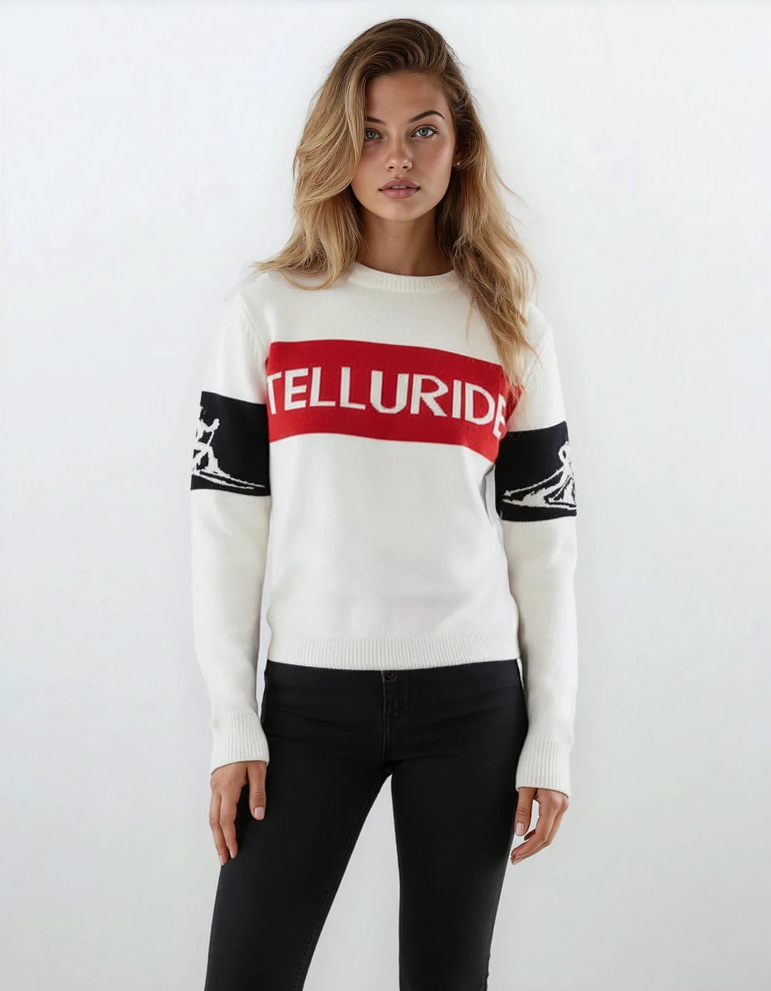 Model wearing Denimaxx Women’s relaxed Telluride ski sweater in white, red, and black with bold “Telluride” front knit