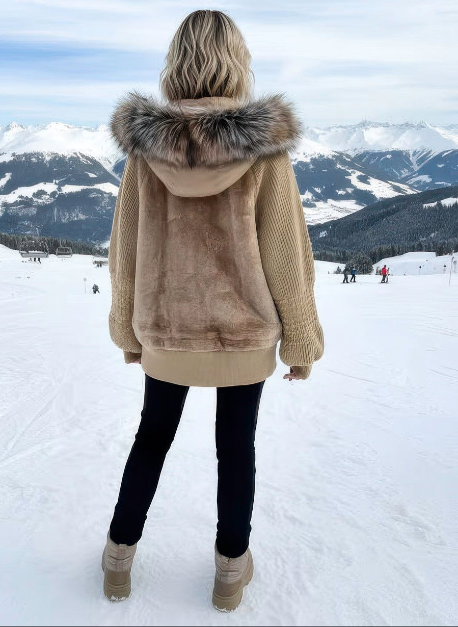 Back view of women’s shearling coat showcasing satin, knit sleeves, and fox hood.

