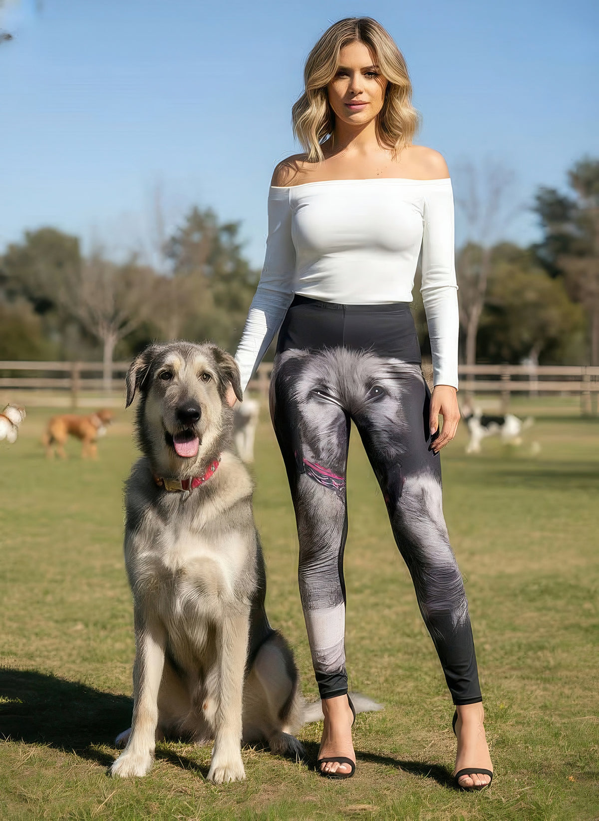 Woman with hands on waistband wearing Irish Wolfhound print leggings with large dog portraits and a black cropped hoodie, studio.