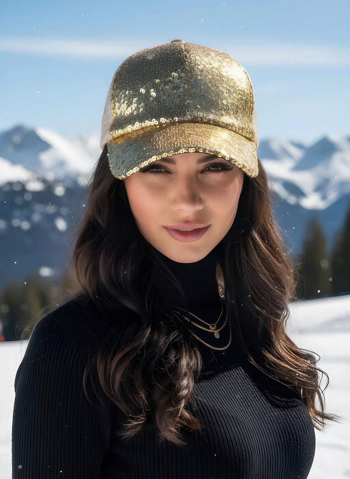 Woman wearing the metallic gold sequin baseball cap with white mesh back panels, snowy mountain backdrop.