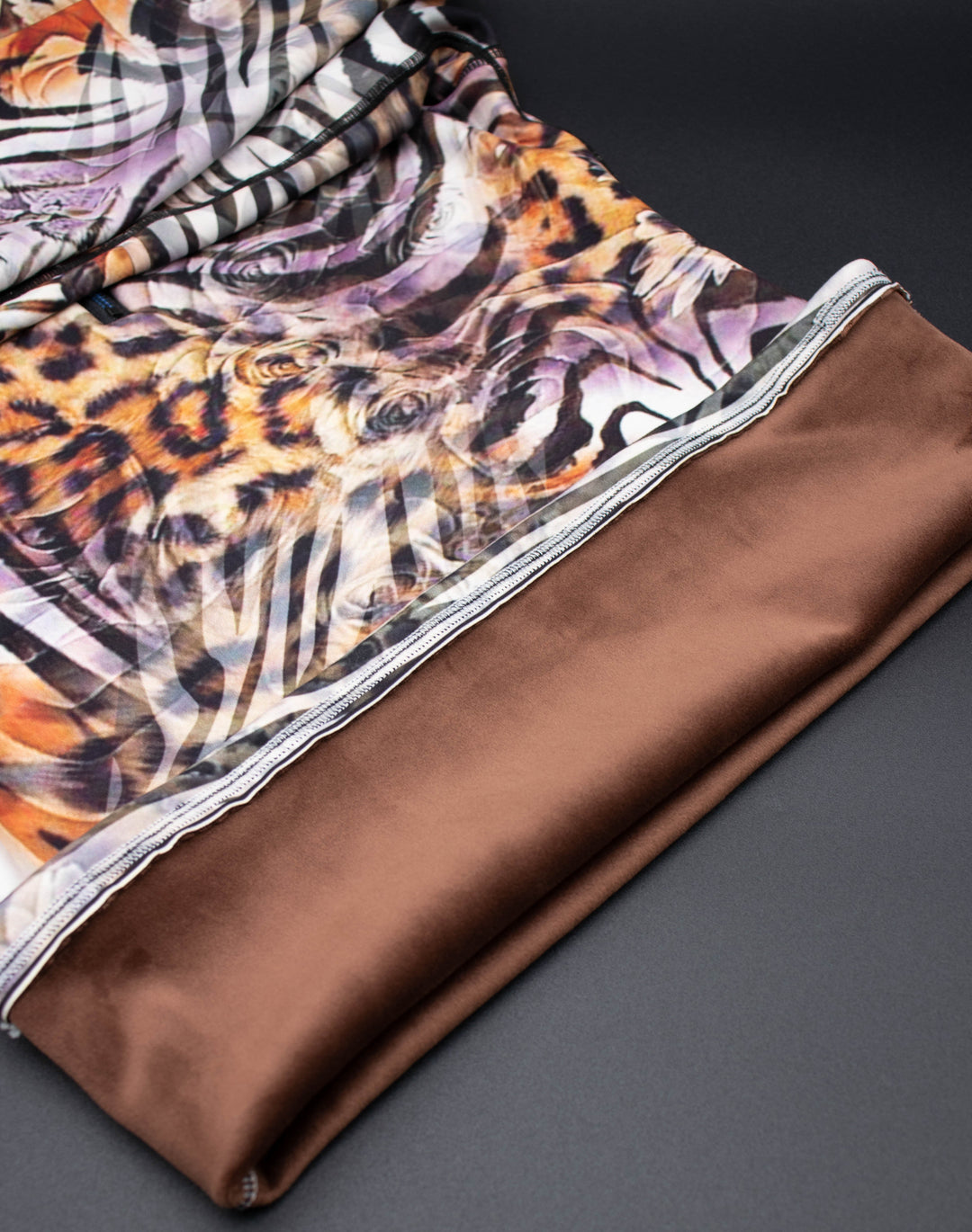 Close-up of Denimaxx Cheetah Mid Layer showing bold animal pattern and smooth nylon texture.

