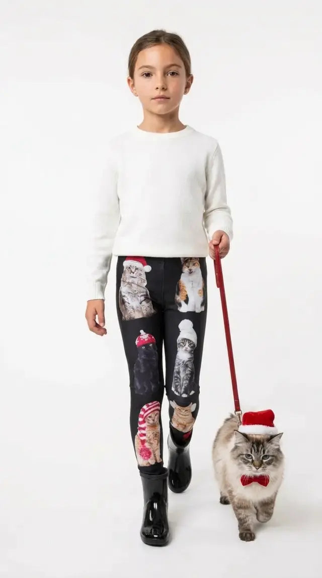 Girl wearing black Christmas cat print kids leggings with a cat in Santa hat