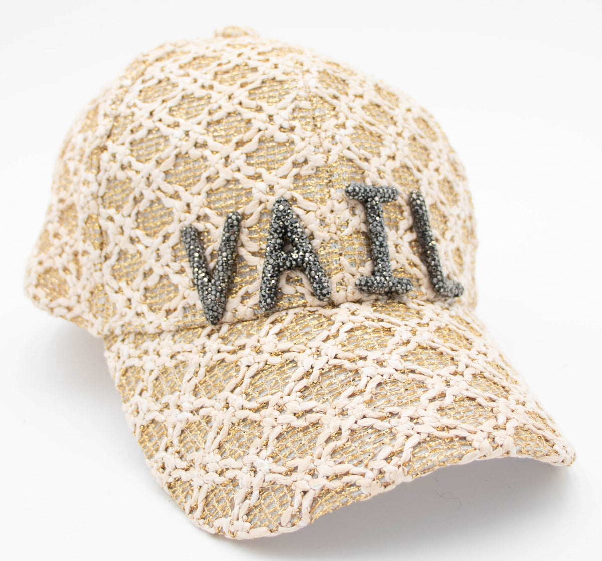 Close-up of the Vail Crystal baseball cap with crystal VAIL letters on cream and gold openwork fabric.