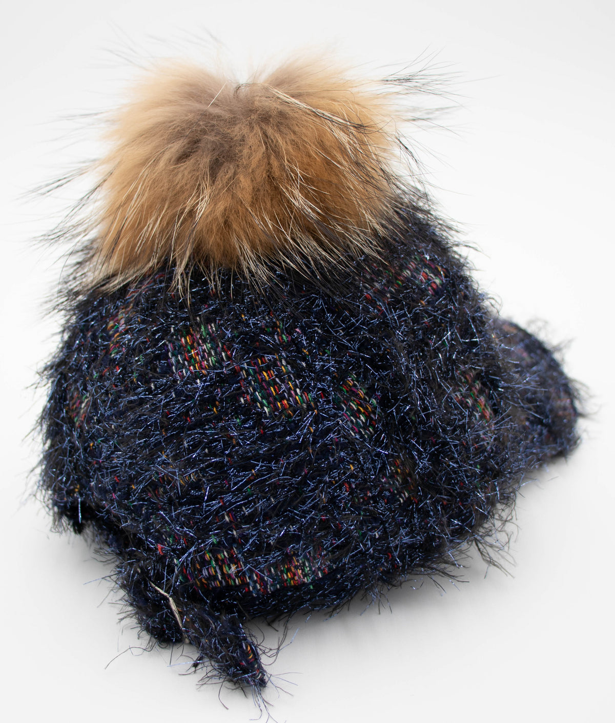 Back view of the Crystal Vail raccoon pom baseball cap showing the navy metallic tweed knit crown and brown fur pom.