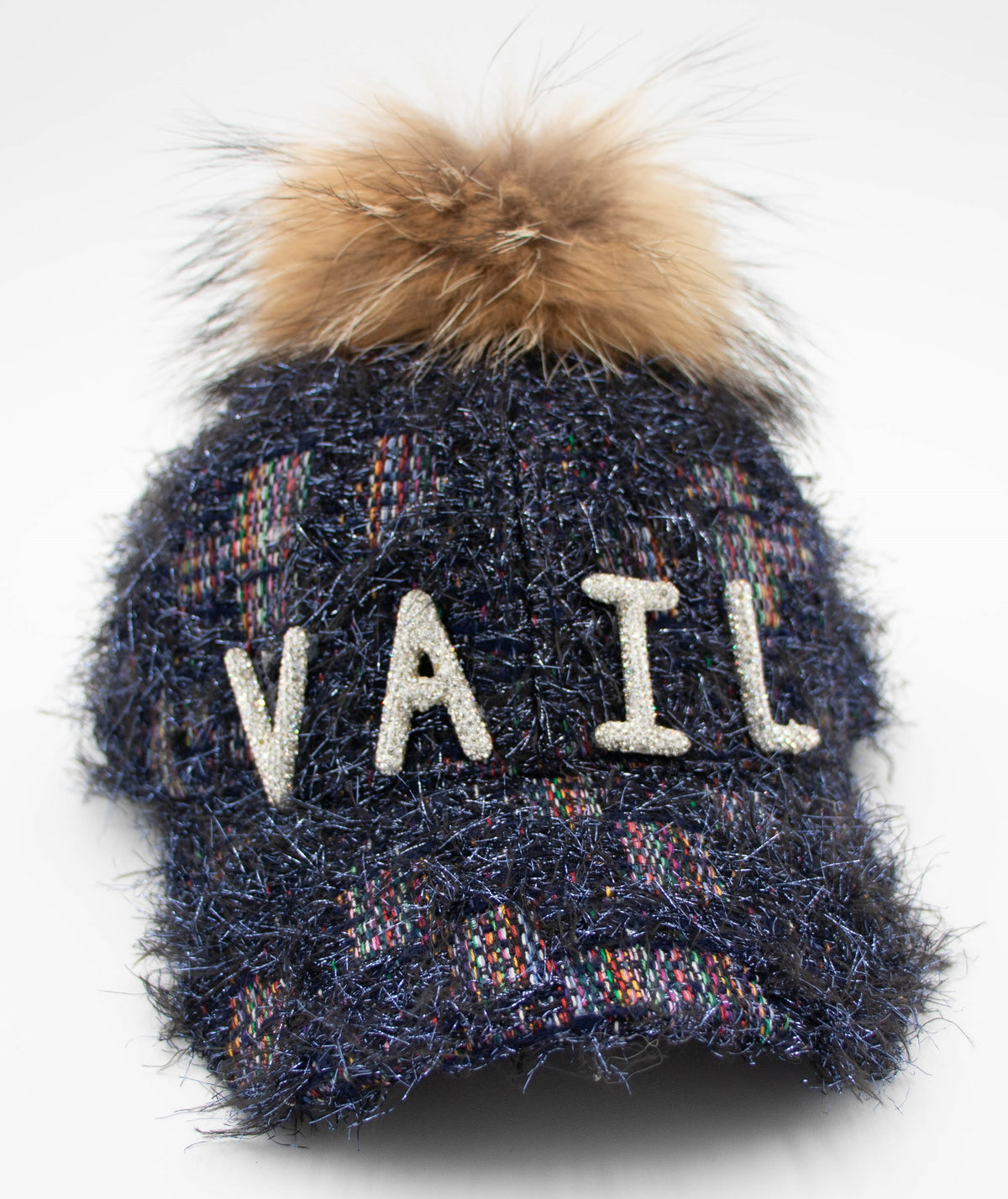 Front view of the Crystal Vail raccoon pom baseball cap with crystal VAIL letters on navy metallic tweed and a brown fur pom.