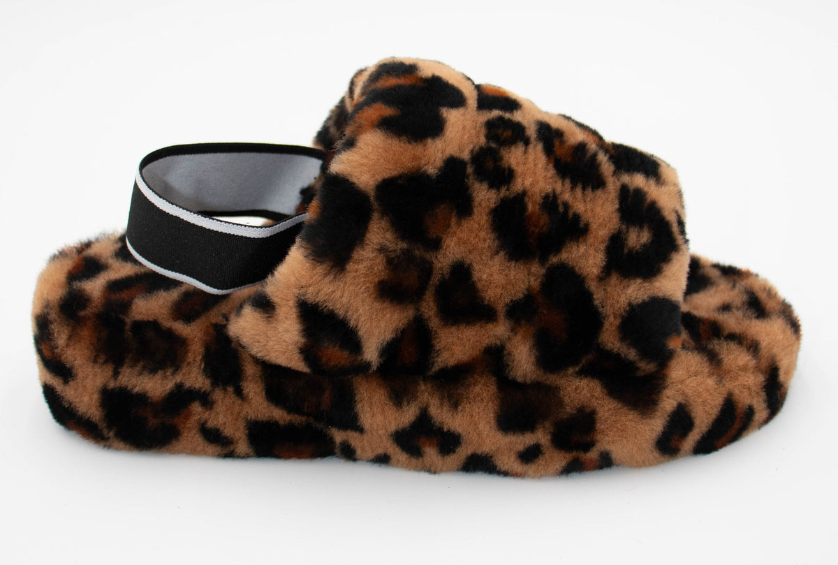 Side view of a single leopard print sheepskin slipper with plush fur upper and black elastic heel strap.