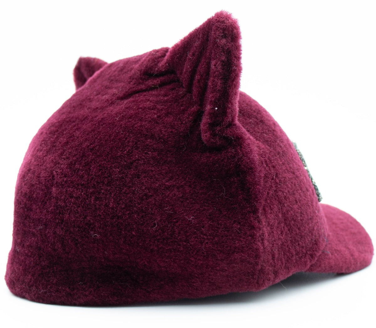Side view of the burgundy faux fur cat ear cap showing the plush ear detail on a white background.