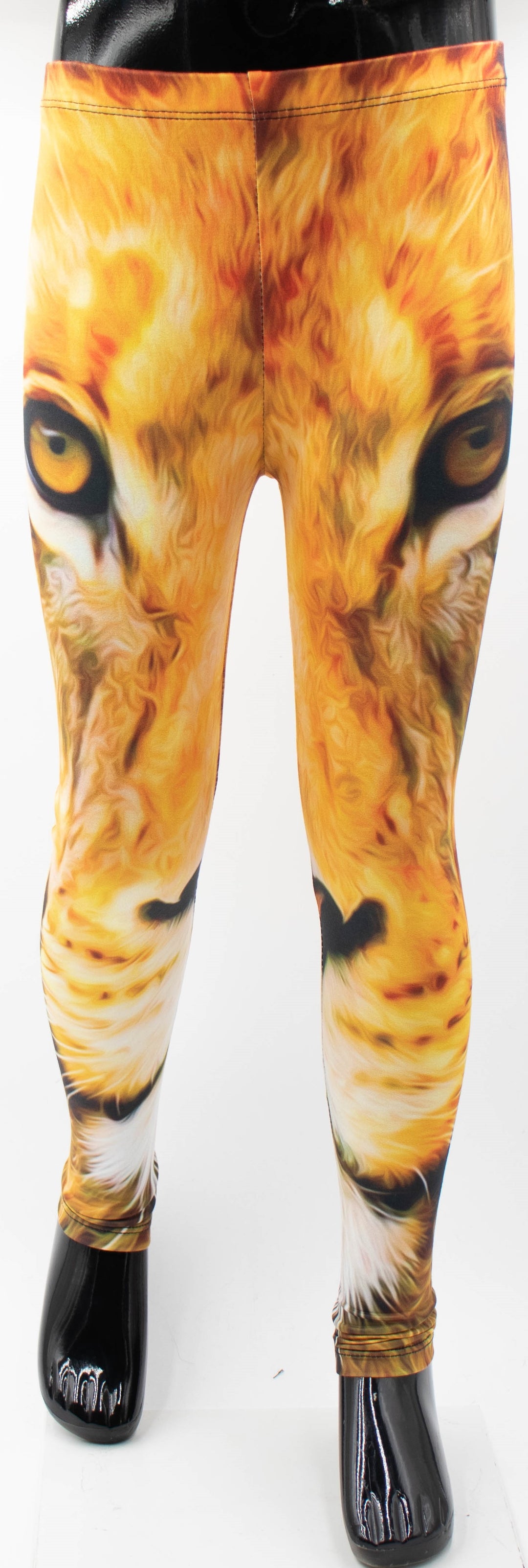 Front view of Denimaxx kids lion print leggings on a mannequin, golden lion face with amber eyes printed down the legs, white studio background.
