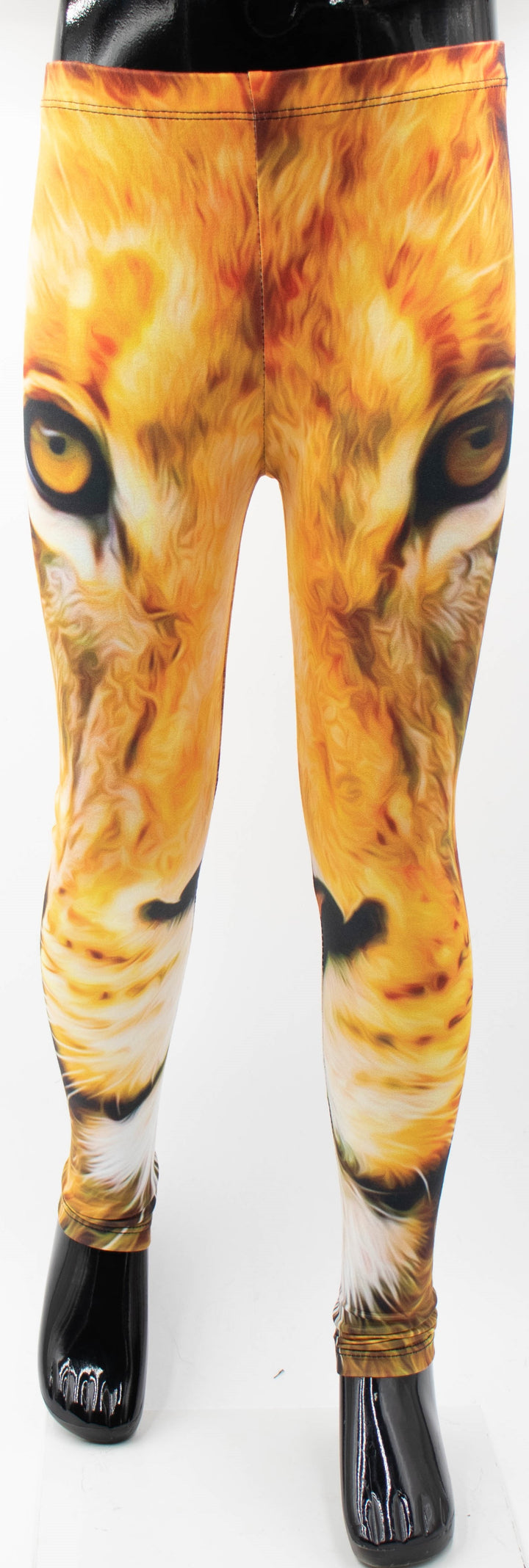 Front view of Denimaxx kids lion print leggings on a mannequin, golden lion face with amber eyes printed down the legs, white studio background.
