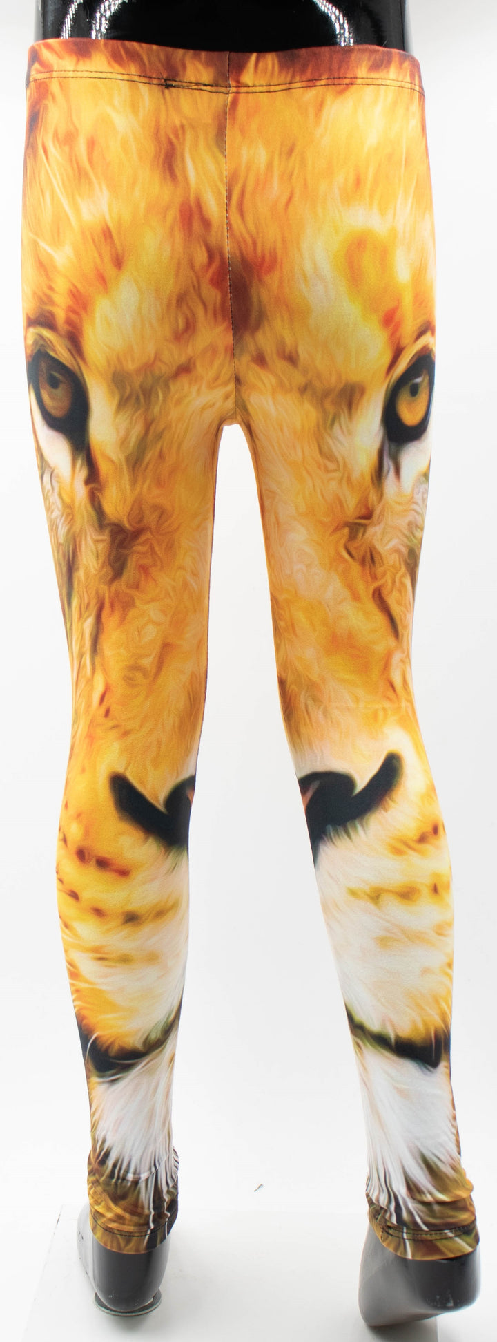 Back view of Denimaxx kids lion print leggings on a mannequin, golden lion face print with amber eyes across the upper legs, white studio background.