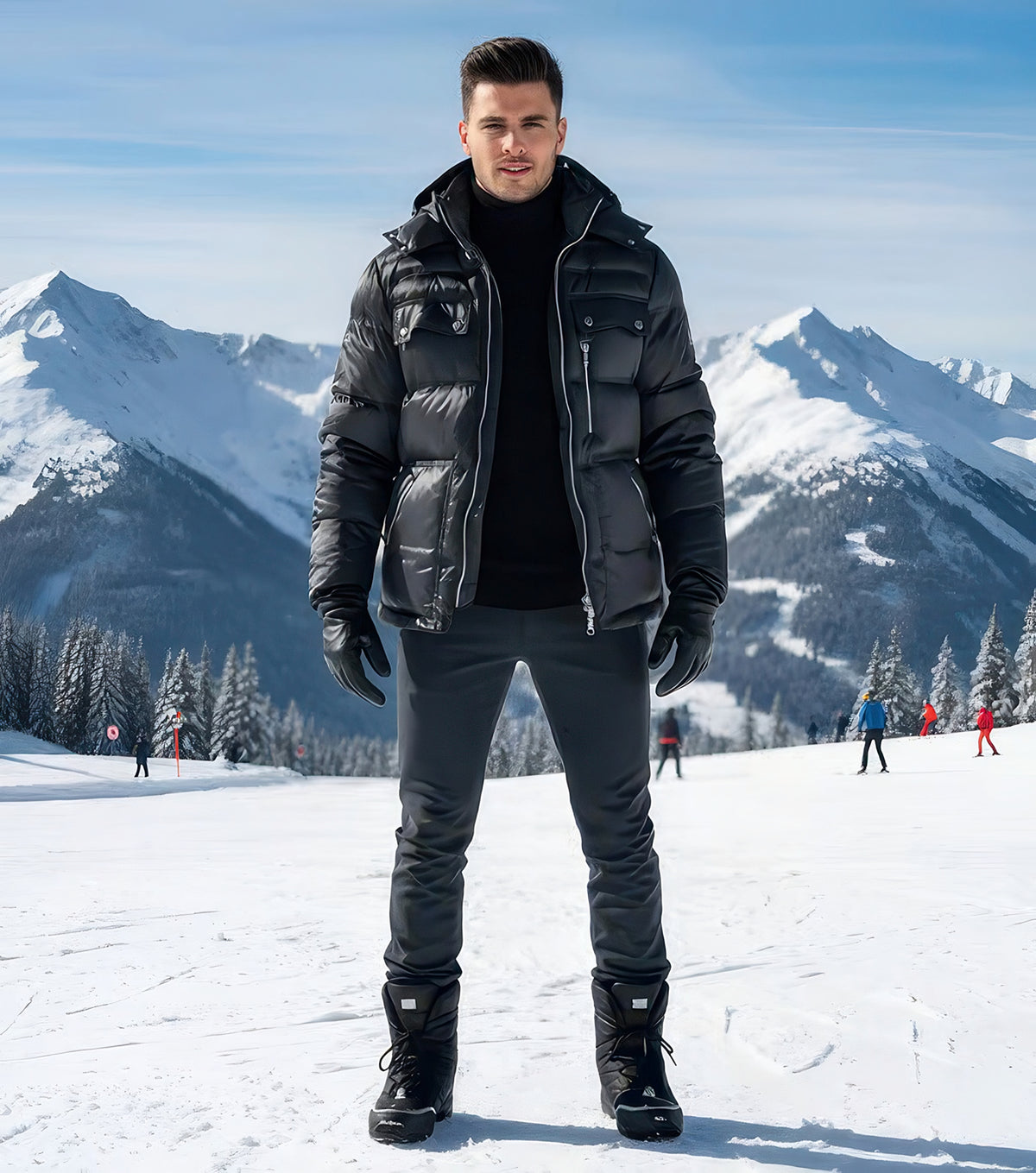 Man standing on a snowy slope wearing the black satin goose down puffer jacket with hood, black turtleneck, gloves, and snow boots.