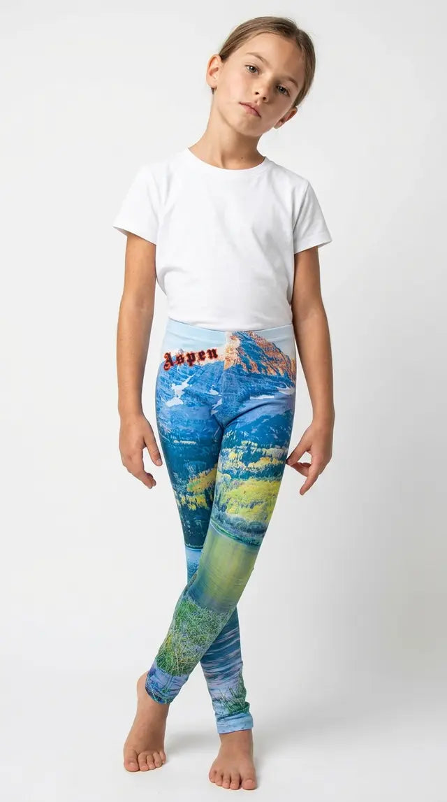 Young girl in a black tank top modeling kids leggings with an Aspen Colorado mountain lake scene print and red Aspen lettering
