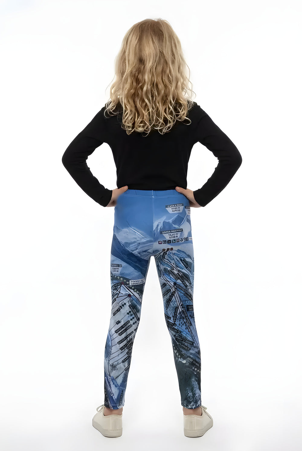 Back view of a girl in a black long-sleeve top wearing blue Aspen Trail Map ski map print girls leggings