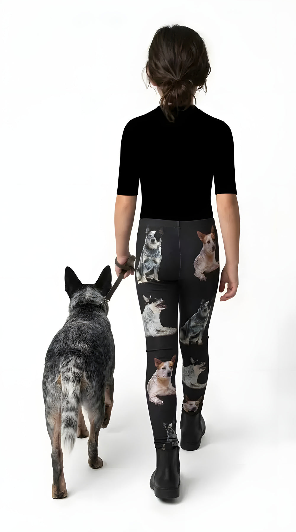 Back view of a girl walking a blue heeler, wearing black Australian Cattle Dog print girls leggings