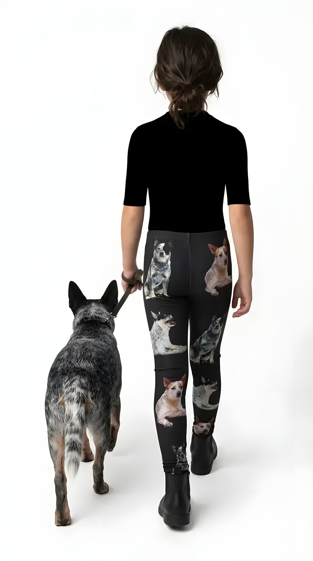 Back view of a girl walking a blue heeler, wearing black Australian Cattle Dog print girls leggings