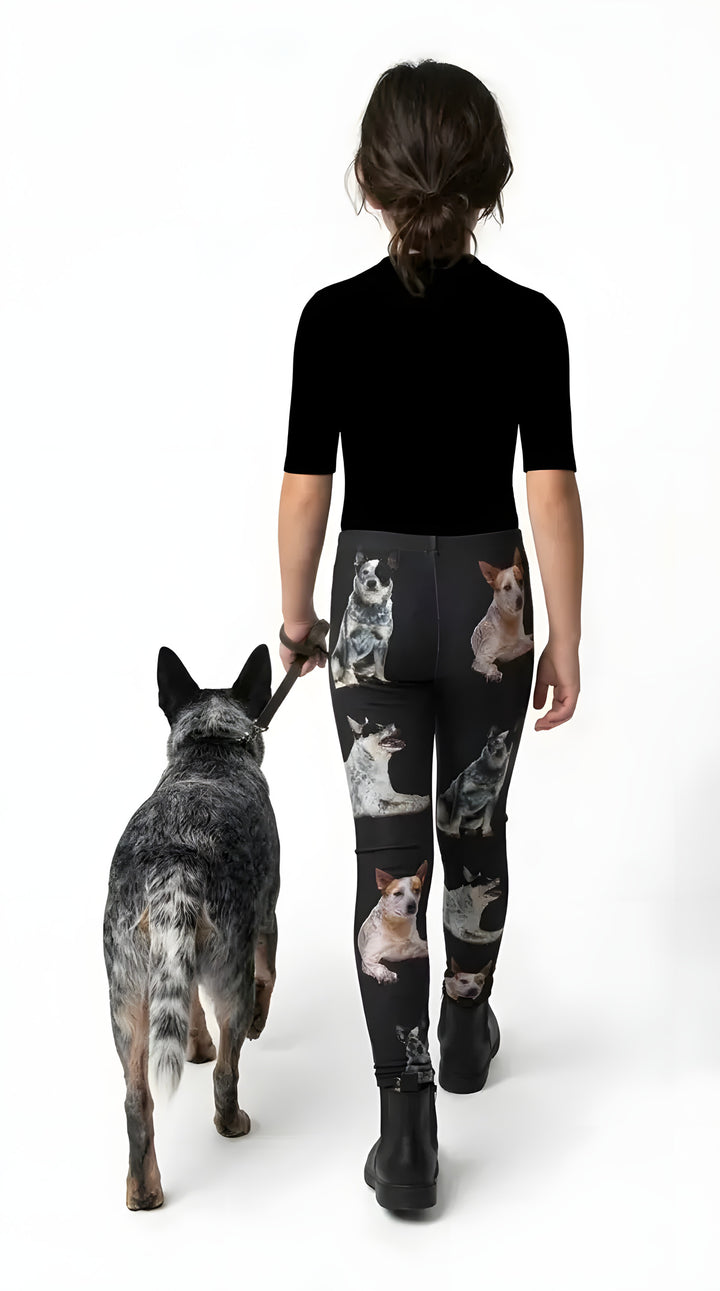 Back view of a girl walking a blue heeler, wearing black Australian Cattle Dog print girls leggings