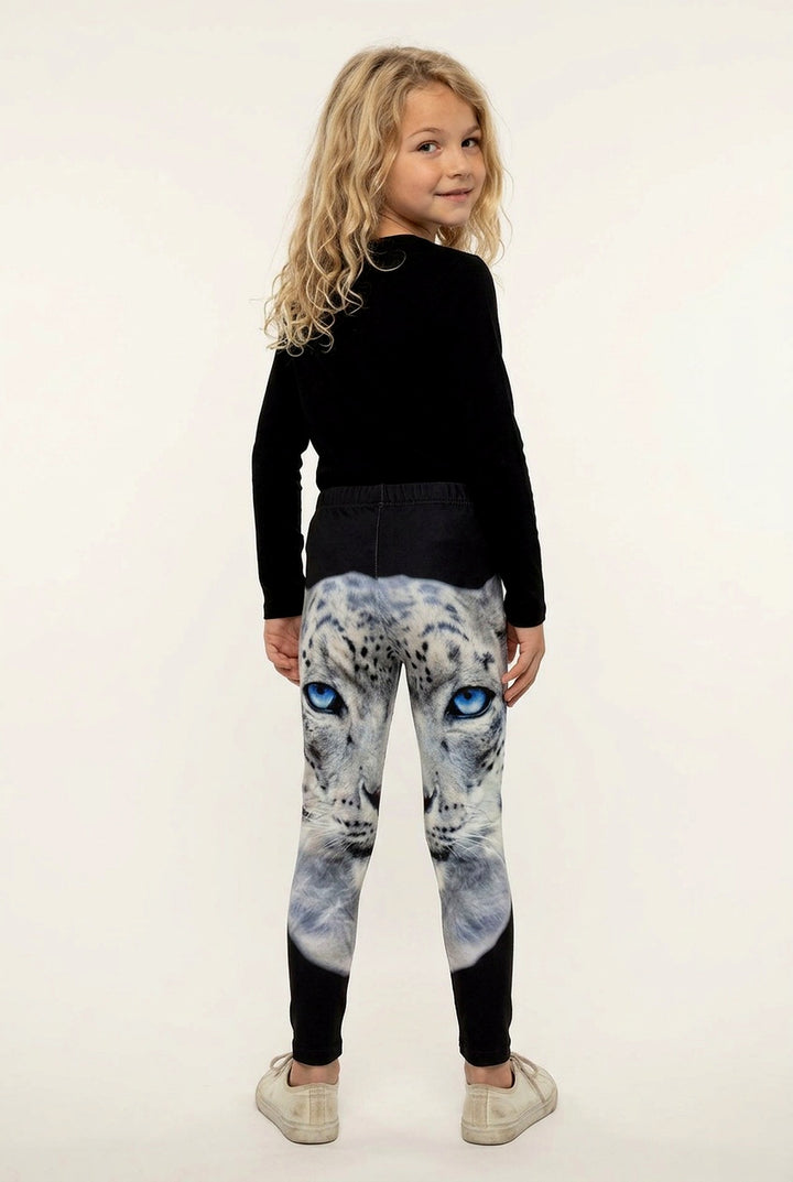 Back view of a girl with long curly hair in snow leopard print girls leggings, solid black below the knee