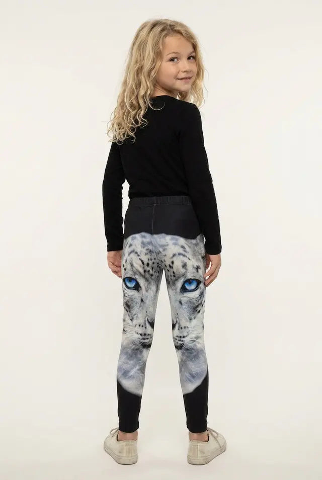 Back view of a girl with long curly hair in snow leopard print girls leggings, solid black below the knee