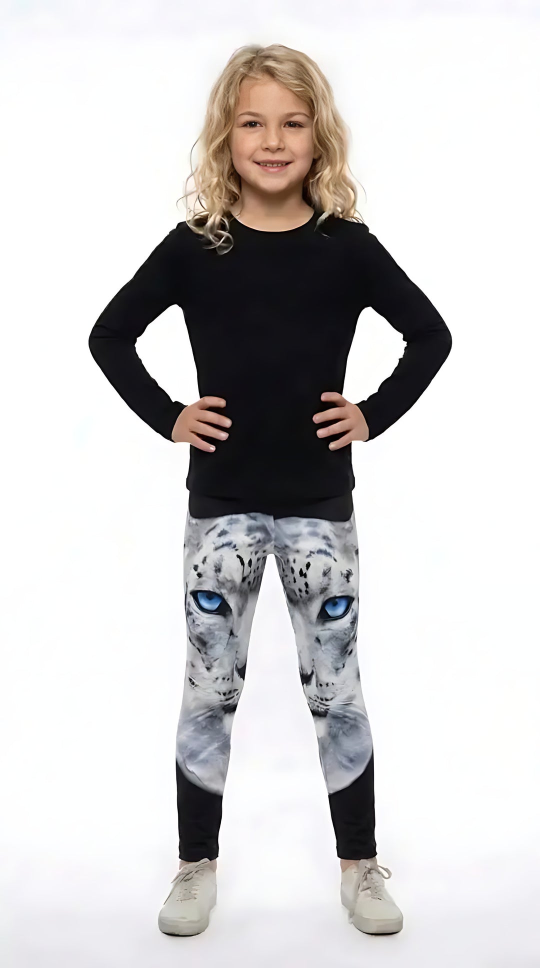 Girl in a black long-sleeve top wearing girls leggings with a blue-eyed white snow leopard face on the upper legs