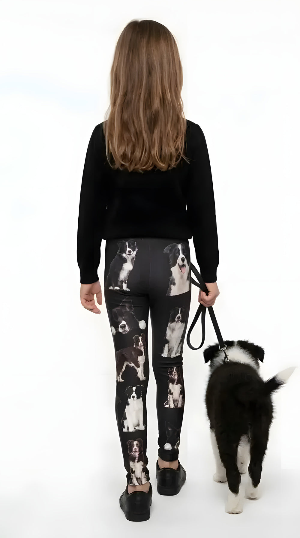 Back view of a girl walking a border collie puppy in black border collie print girls leggings