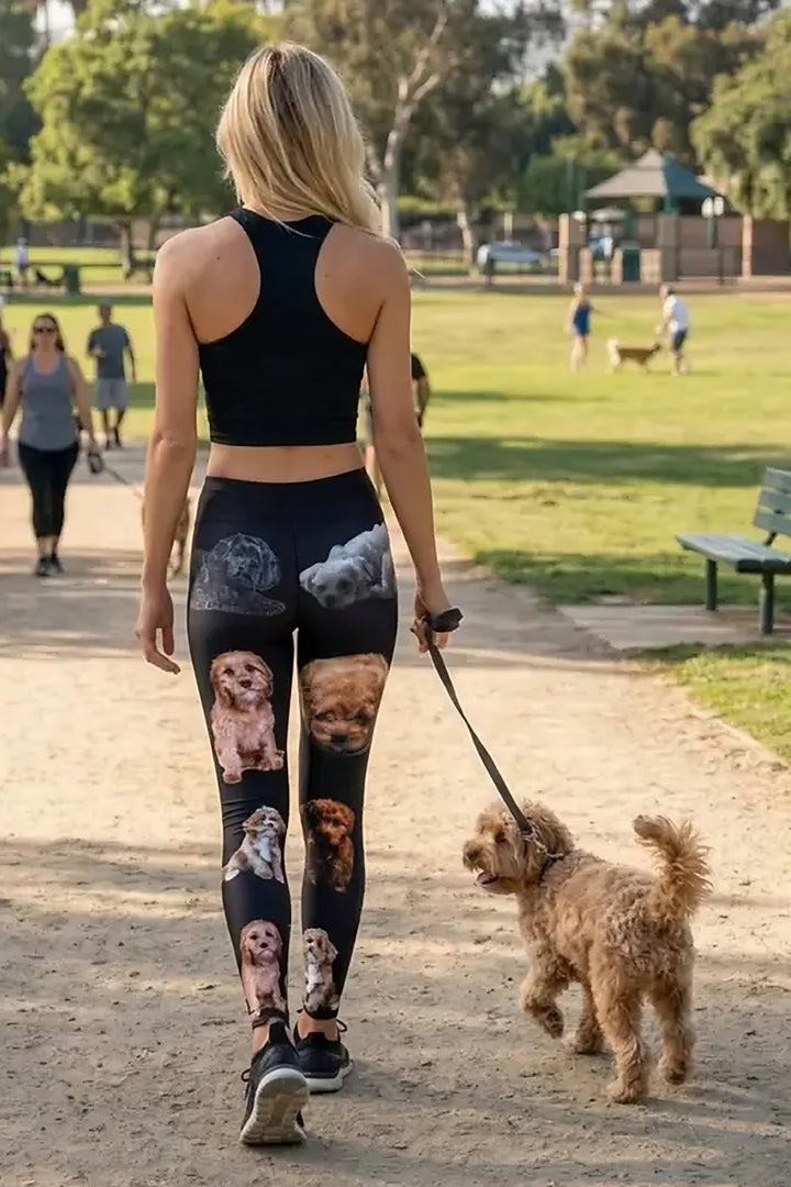 Back view of a woman walking an apricot cavapoo on a park path in black cavapoo print leggings