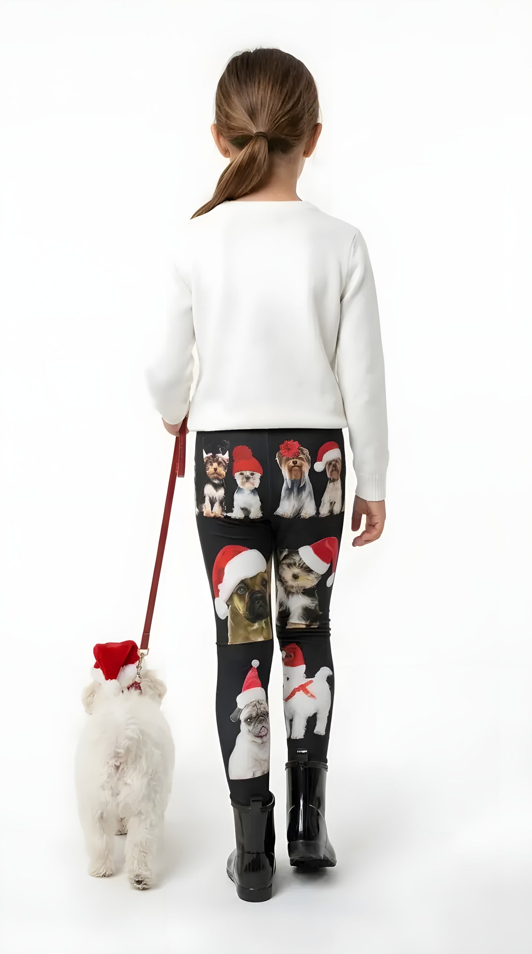 Back view of a girl in a cream sweater walking a white dog in a Santa hat, wearing Christmas dogs print girls leggings