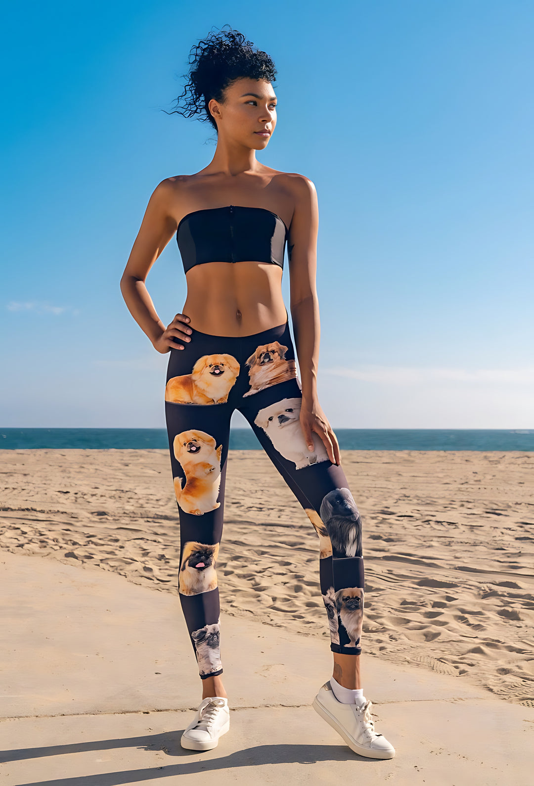 Woman wearing Pekingese print leggings and a black strapless top on a sunny beach boardwalk by the ocean.