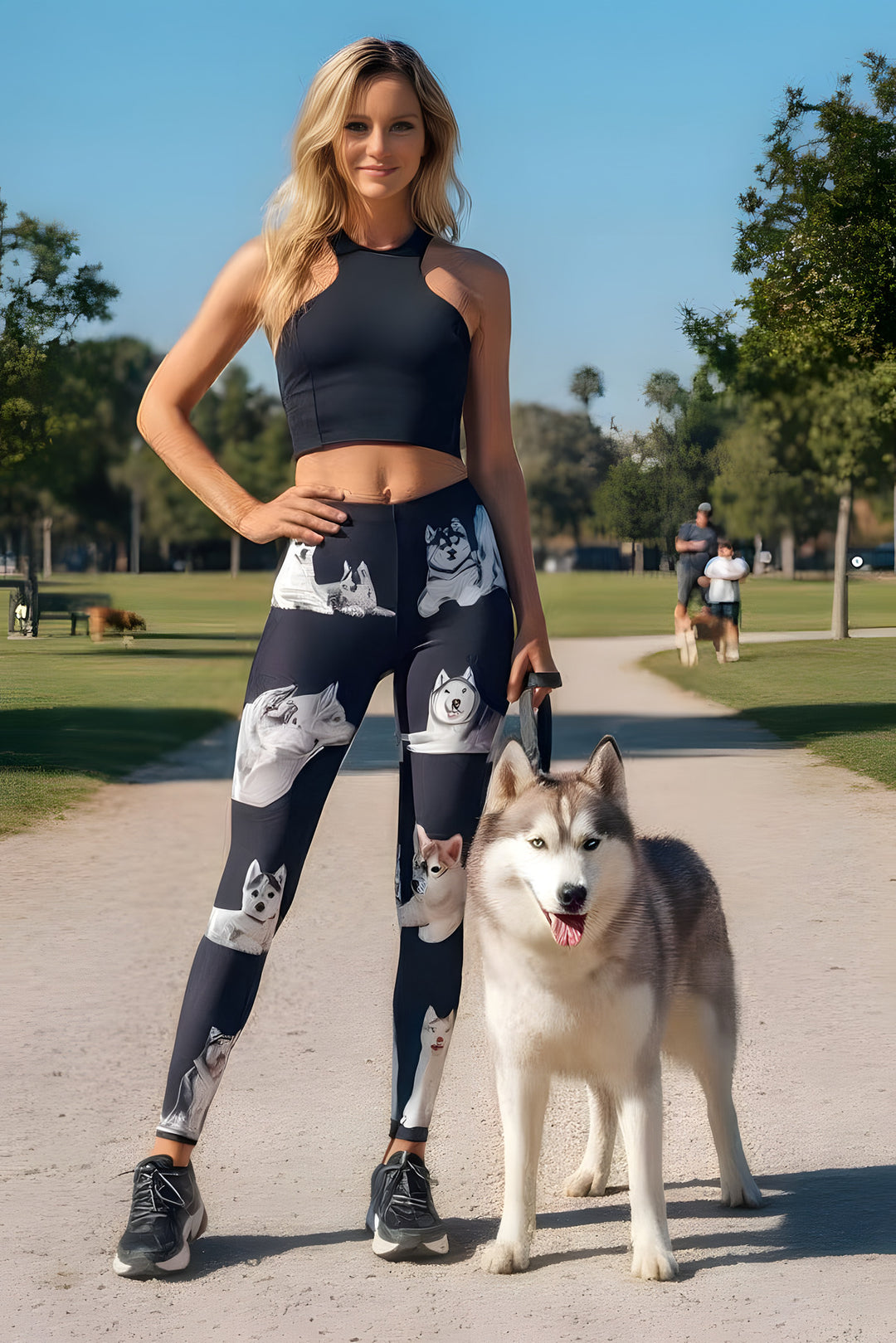 Woman wearing Siberian Husky print leggings and a black crop top, walking a real Husky on a park path.