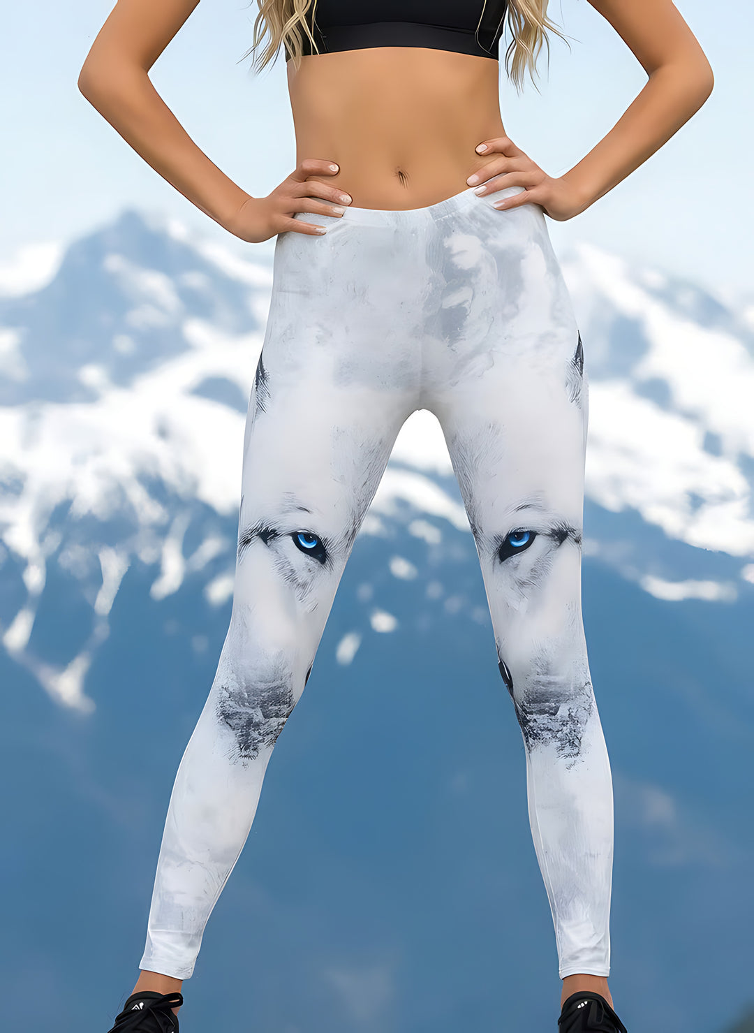 Close-up of Arctic Wolf print leggings showing the detailed white wolf face with striking blue eyes against snowy mountains.