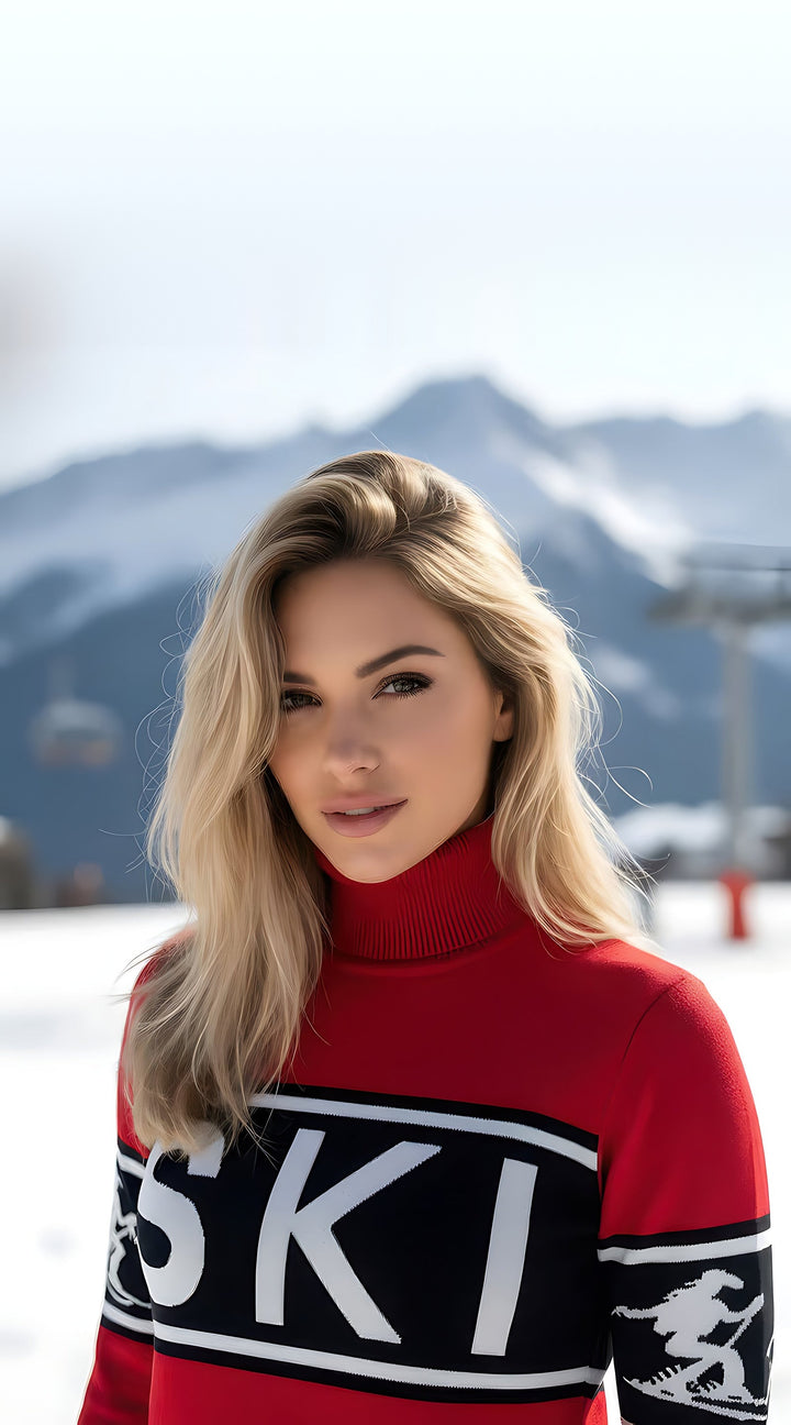Close-up of the red Cowgirl Ski turtleneck sweater with black SKI lettering band and white skier intarsia on the sleeve.