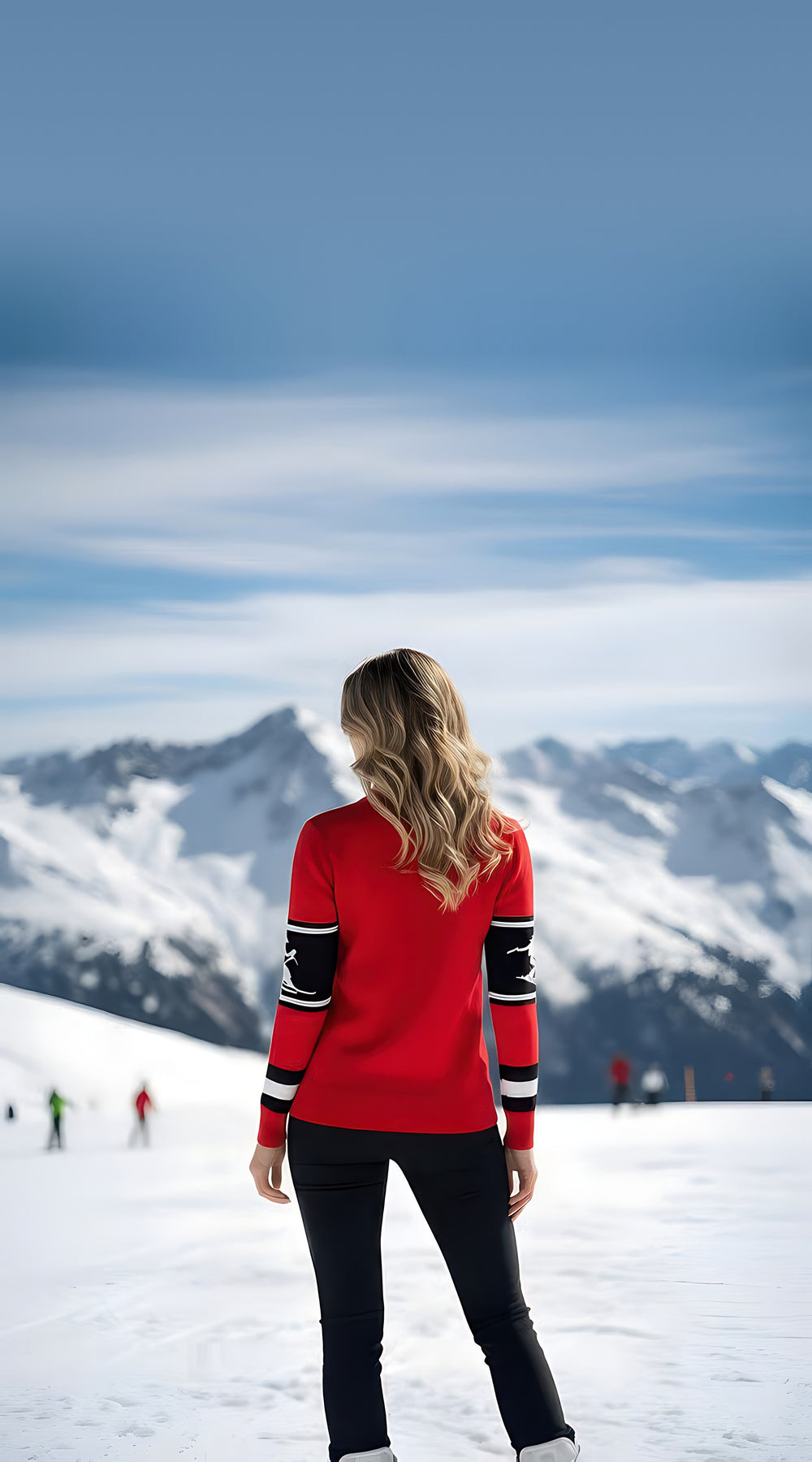 Back view of woman wearing the red Telluride turtleneck ski sweater with striped sleeves, facing snowy peaks with skiers behind.
