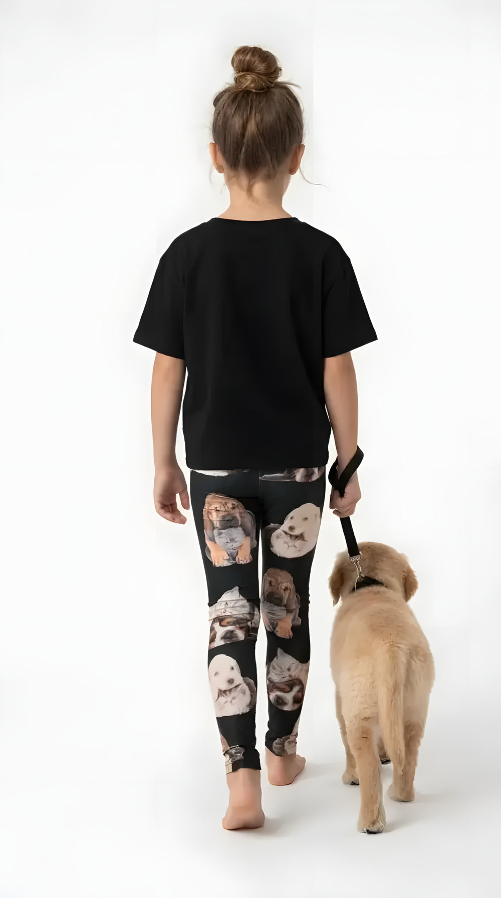 Back view of a girl walking a golden puppy, wearing black kitten and puppy print girls leggings