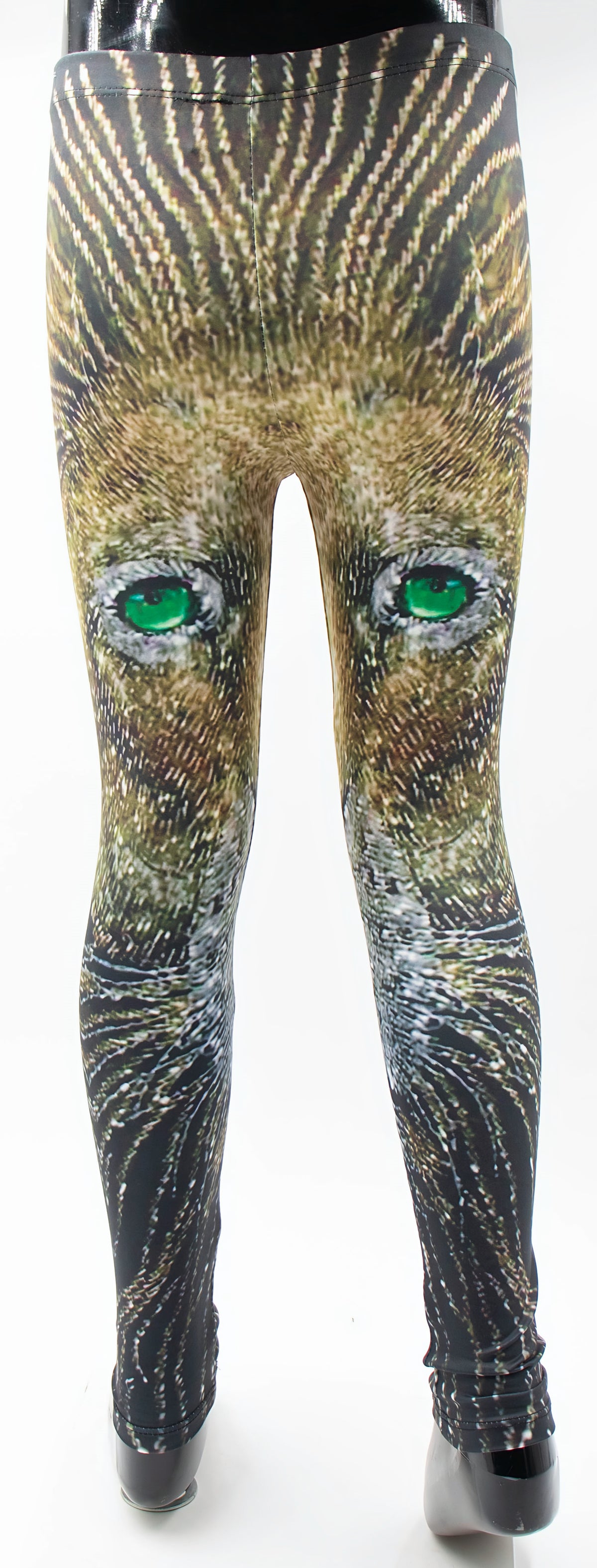 Back view of kids lion print leggings on a mannequin, lion face with vivid green eyes printed in golden brown fur tones.