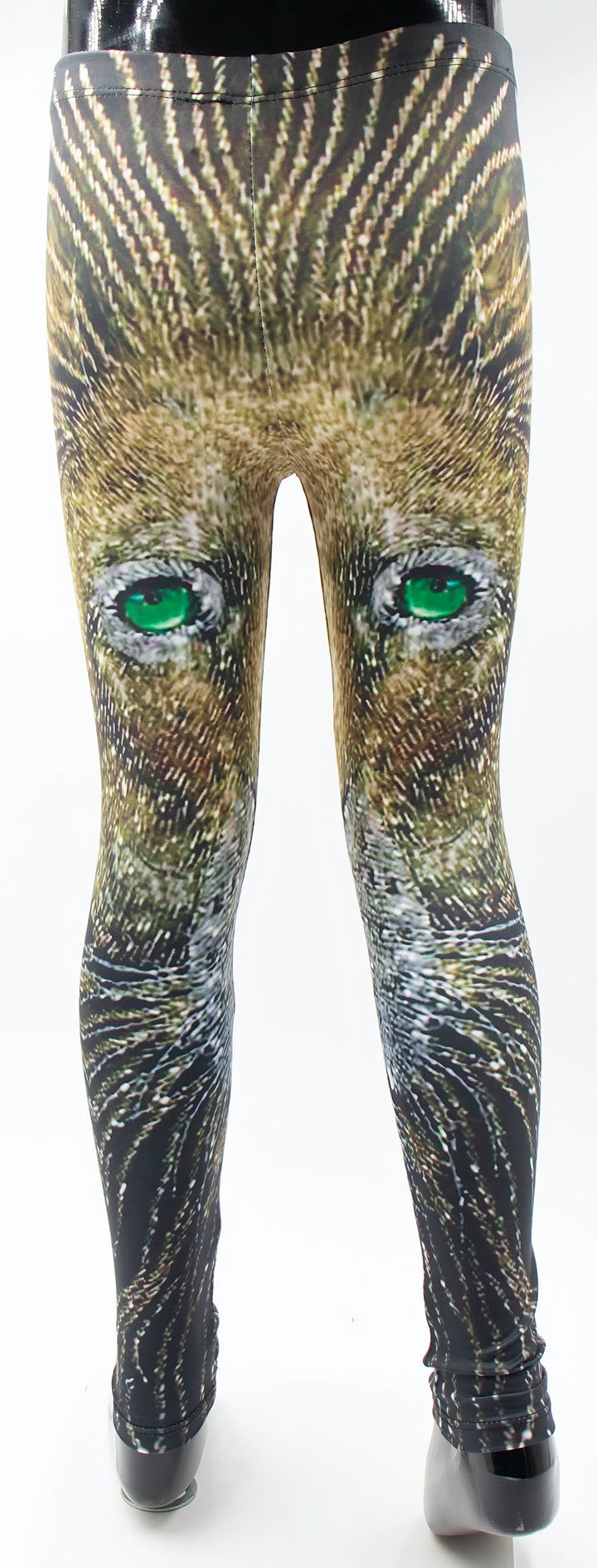 Back view of kids lion print leggings on a mannequin, lion face with vivid green eyes printed in golden brown fur tones.