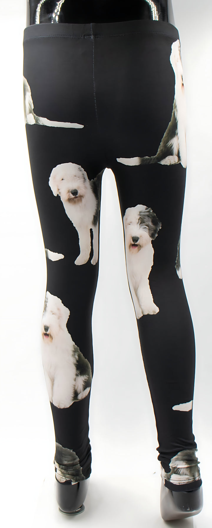 Back view of kids English Sheepdog print leggings with white sheepdog photos on black, shown on a mannequin.