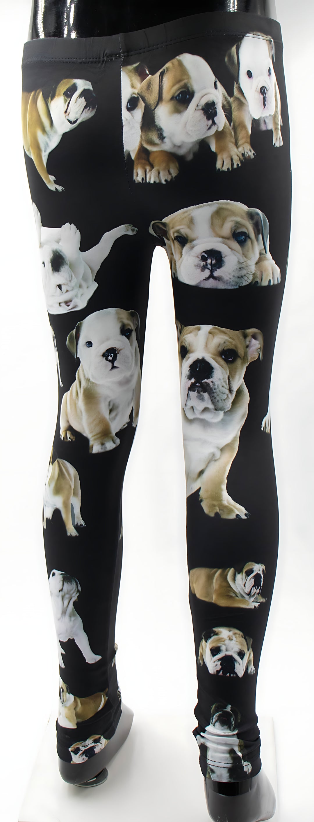 Kids English Bulldog print leggings with scattered bulldog puppy prints on black, front view on a child mannequin.