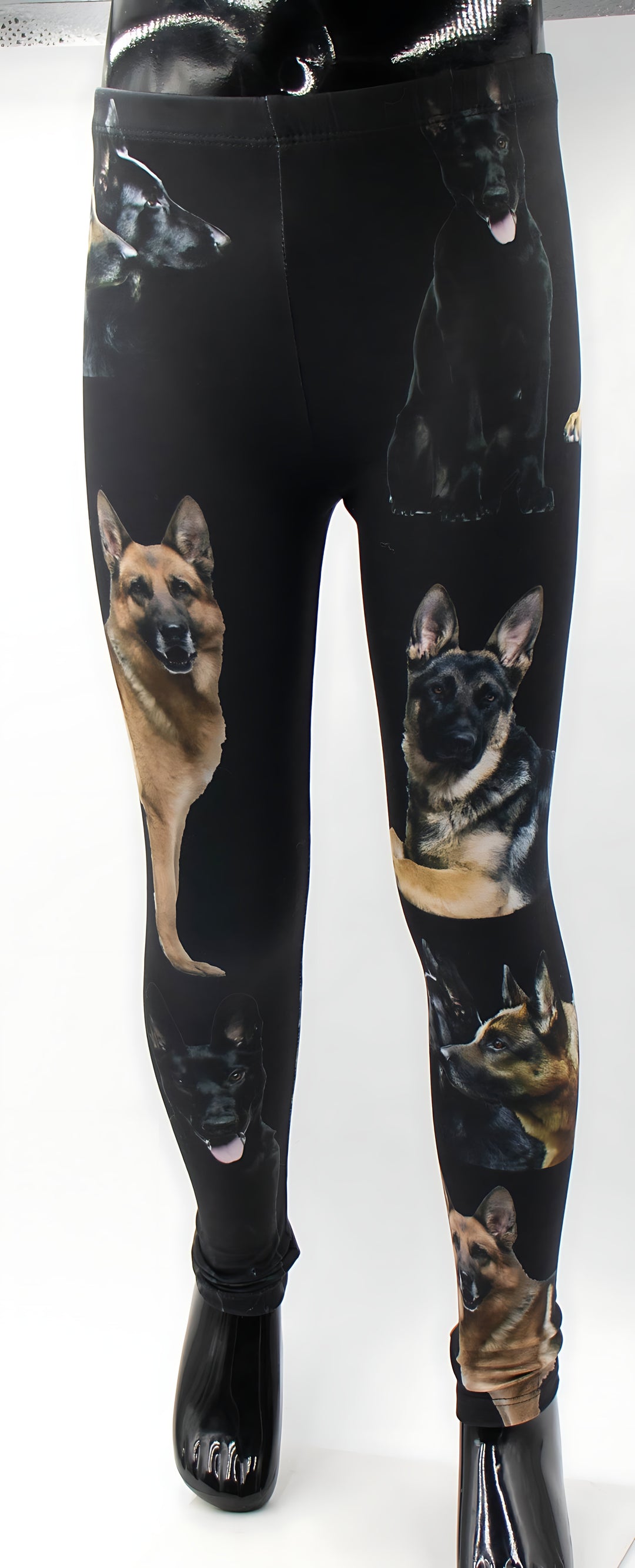 Close-up of kids German Shepherd print leggings on a mannequin, tan and black shepherd portraits on black fabric.