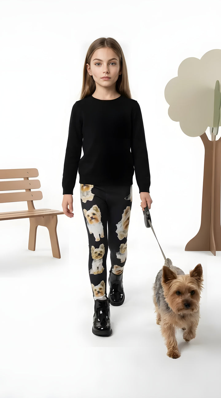 Girl in a black sweater walking a Yorkie, wearing black Yorkie puppy print girls leggings