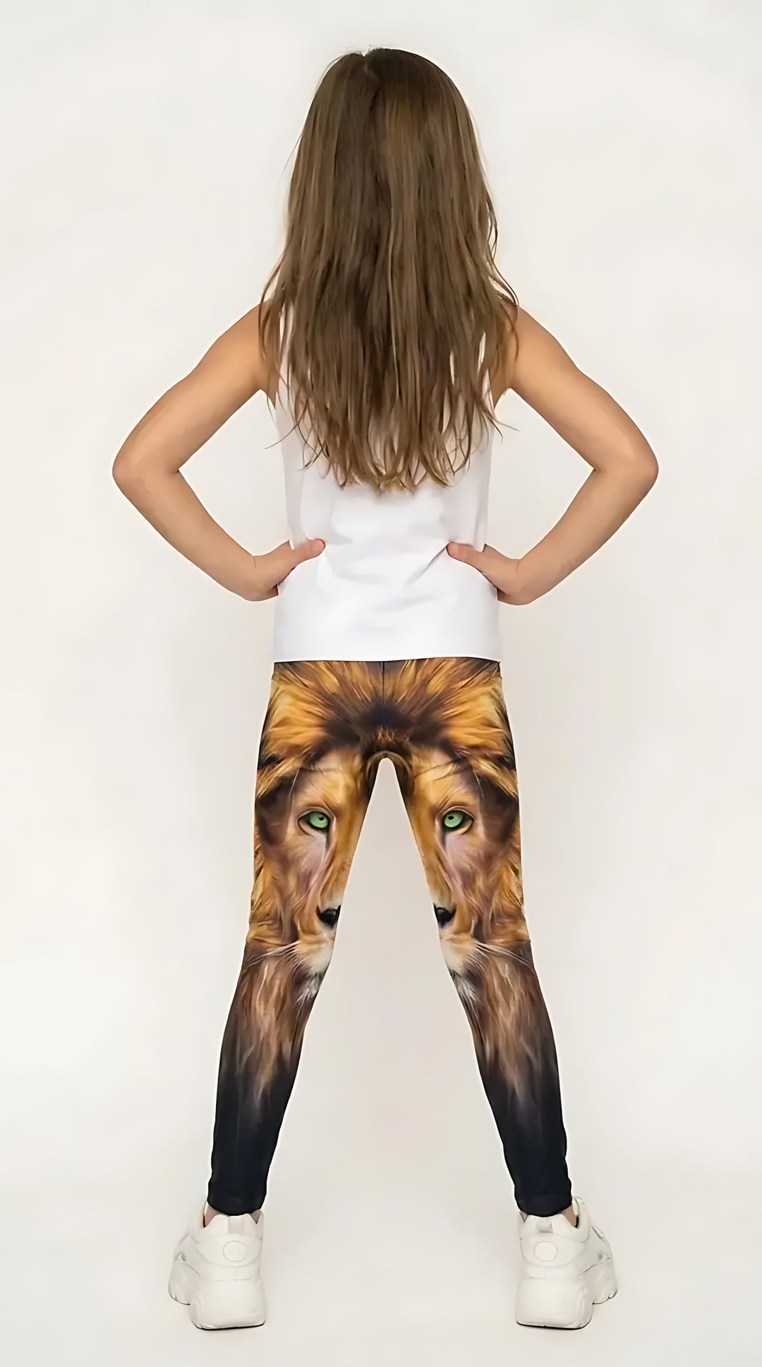 Back view of a girl in a white tank top wearing golden lion face print girls leggings with green eyes