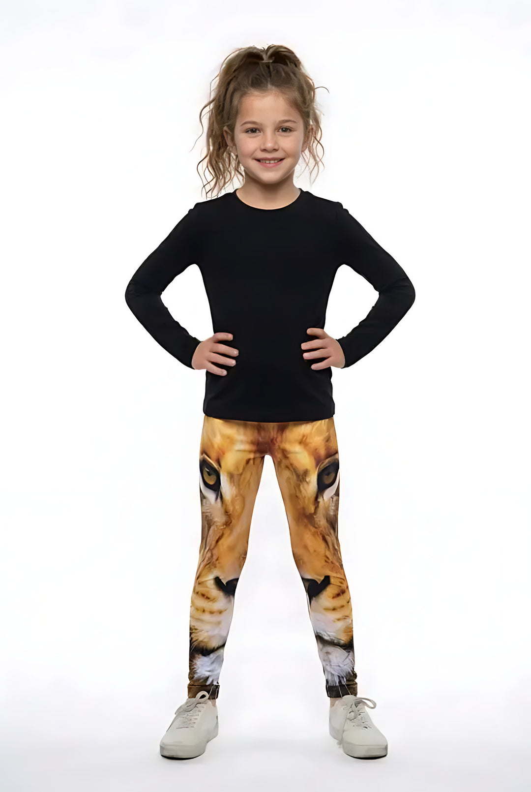 Girl in a black long-sleeve top and white sneakers wearing golden lion face print girls leggings with amber eyes