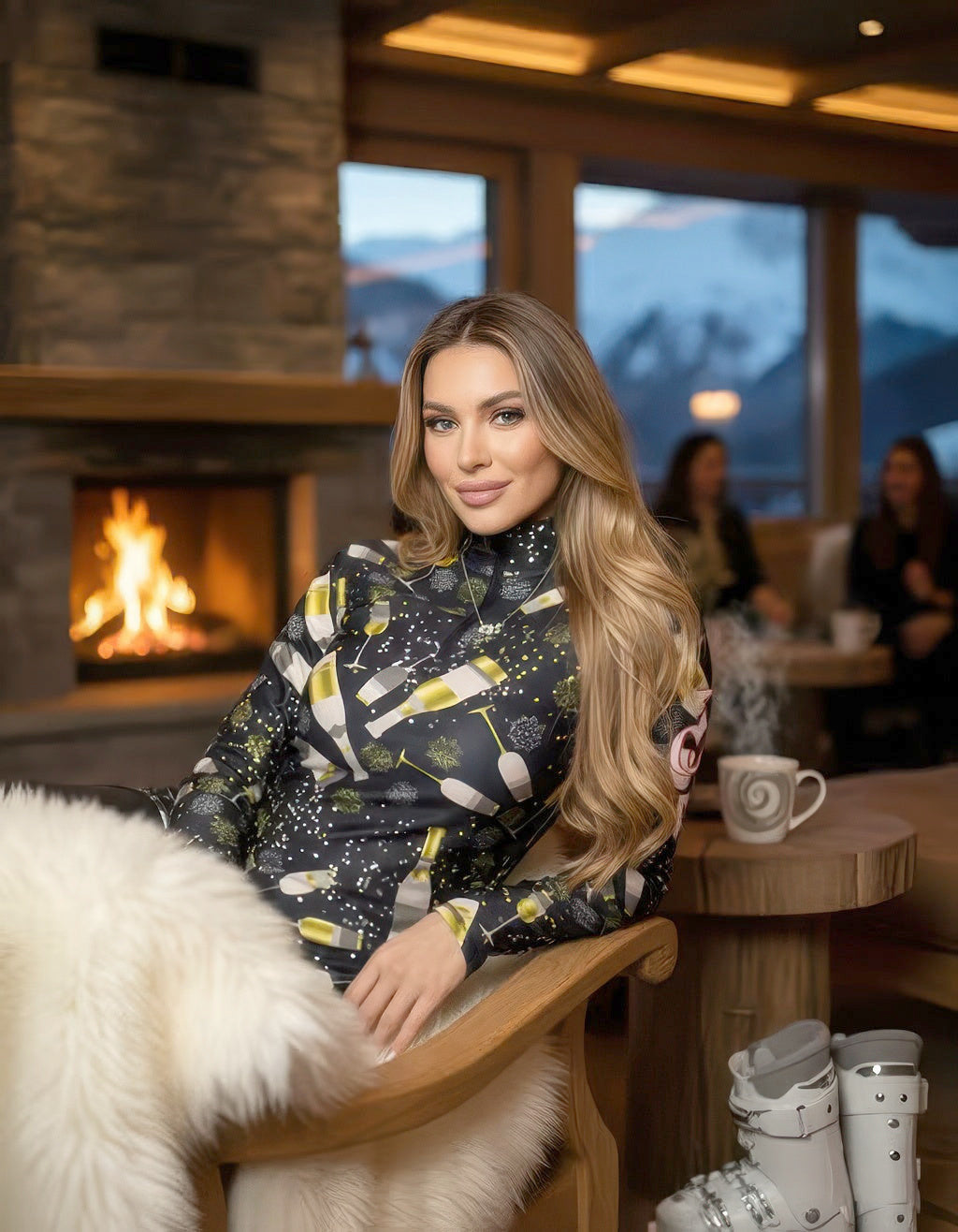 Woman relaxing in a fur-draped chair by a stone fireplace, wearing the black champagne print mid-layer top in a mountain lodge.