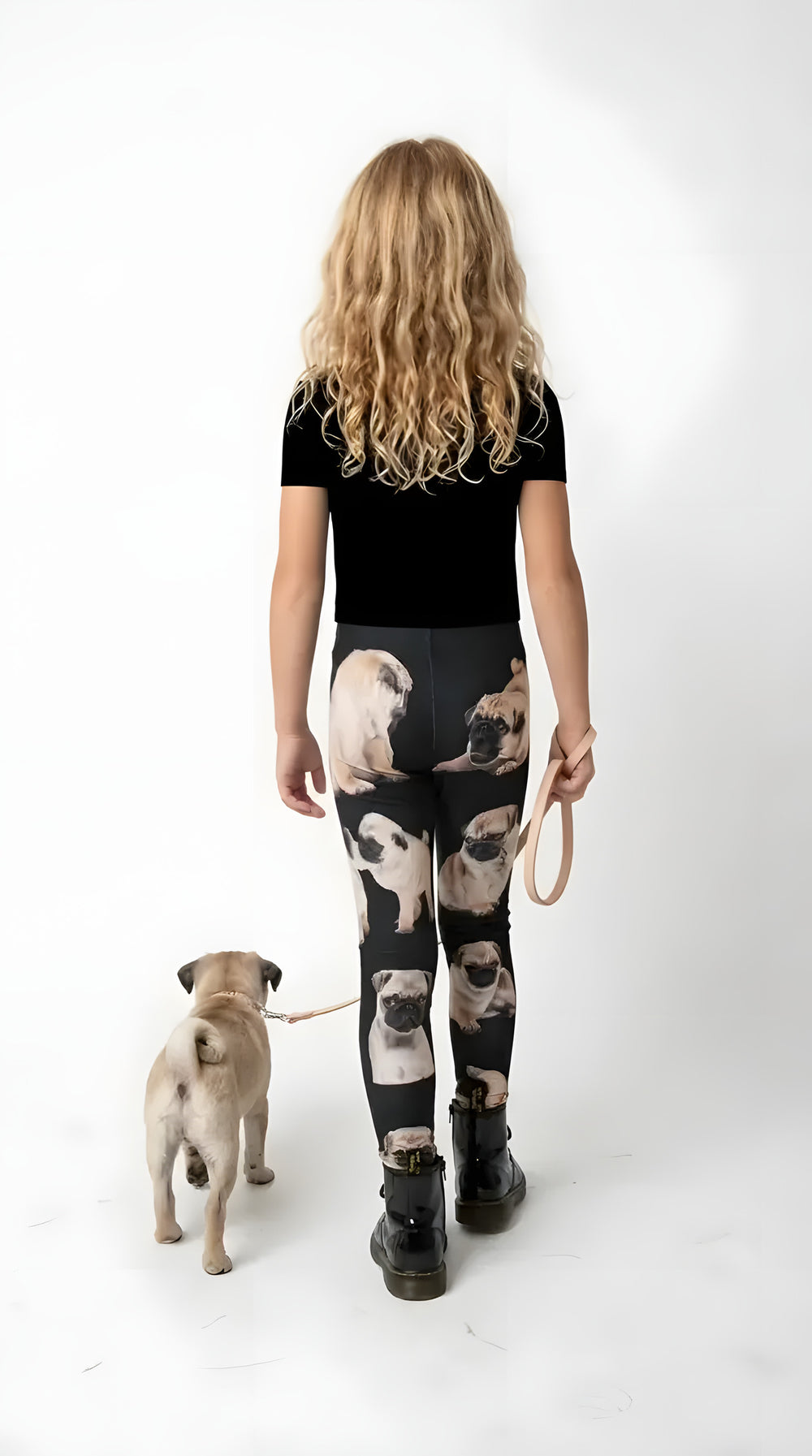 Back view of a girl walking a fawn pug puppy, wearing black pug puppy print girls leggings