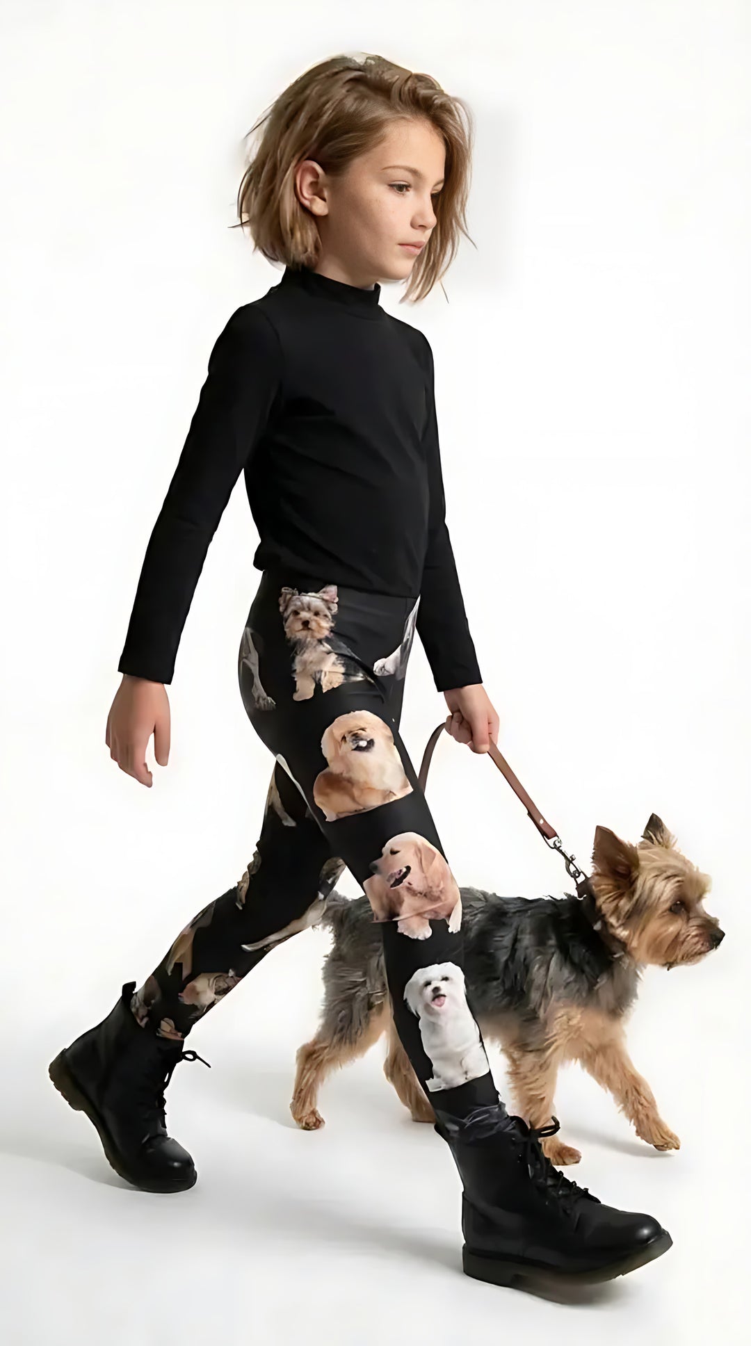 Girl in a black mock-neck top and boots walking a Yorkie, wearing black girls leggings with small dog breed portraits