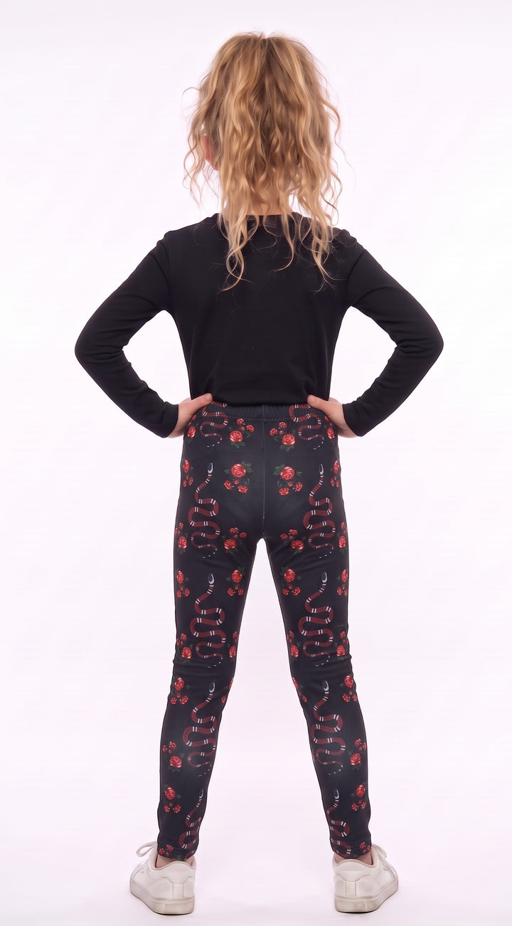 Girl wearing black leggings with red snakes and roses, back view