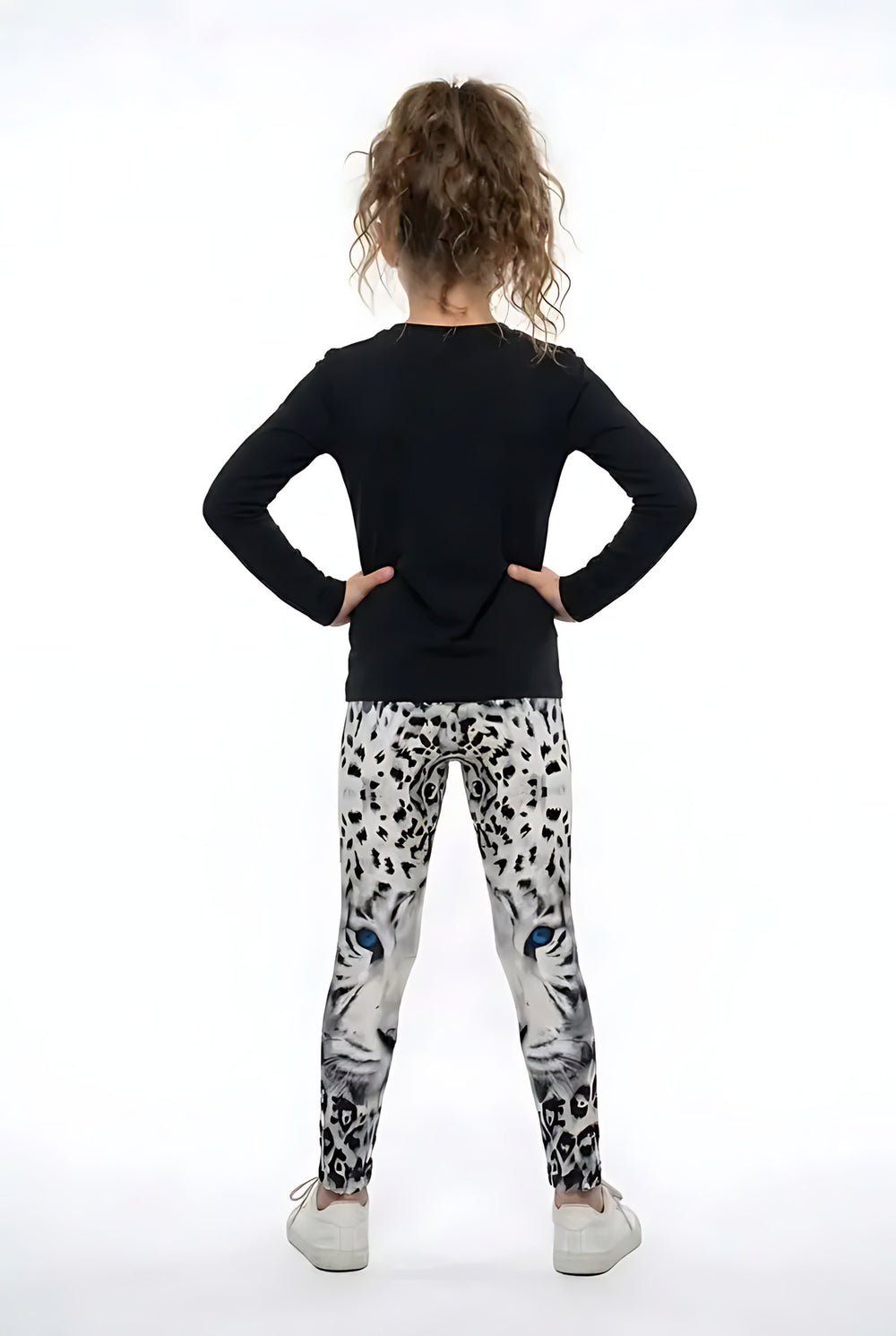 Back view of a girl in a black top wearing spotted snow leopard print girls leggings