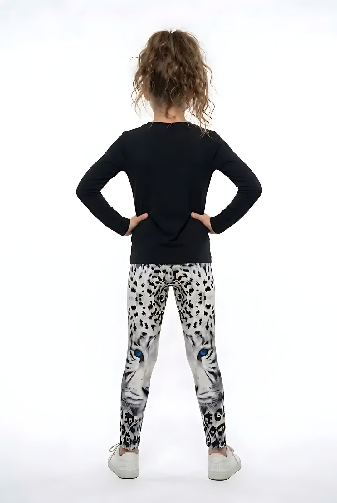 Back view of a girl in a black top wearing spotted snow leopard print girls leggings
