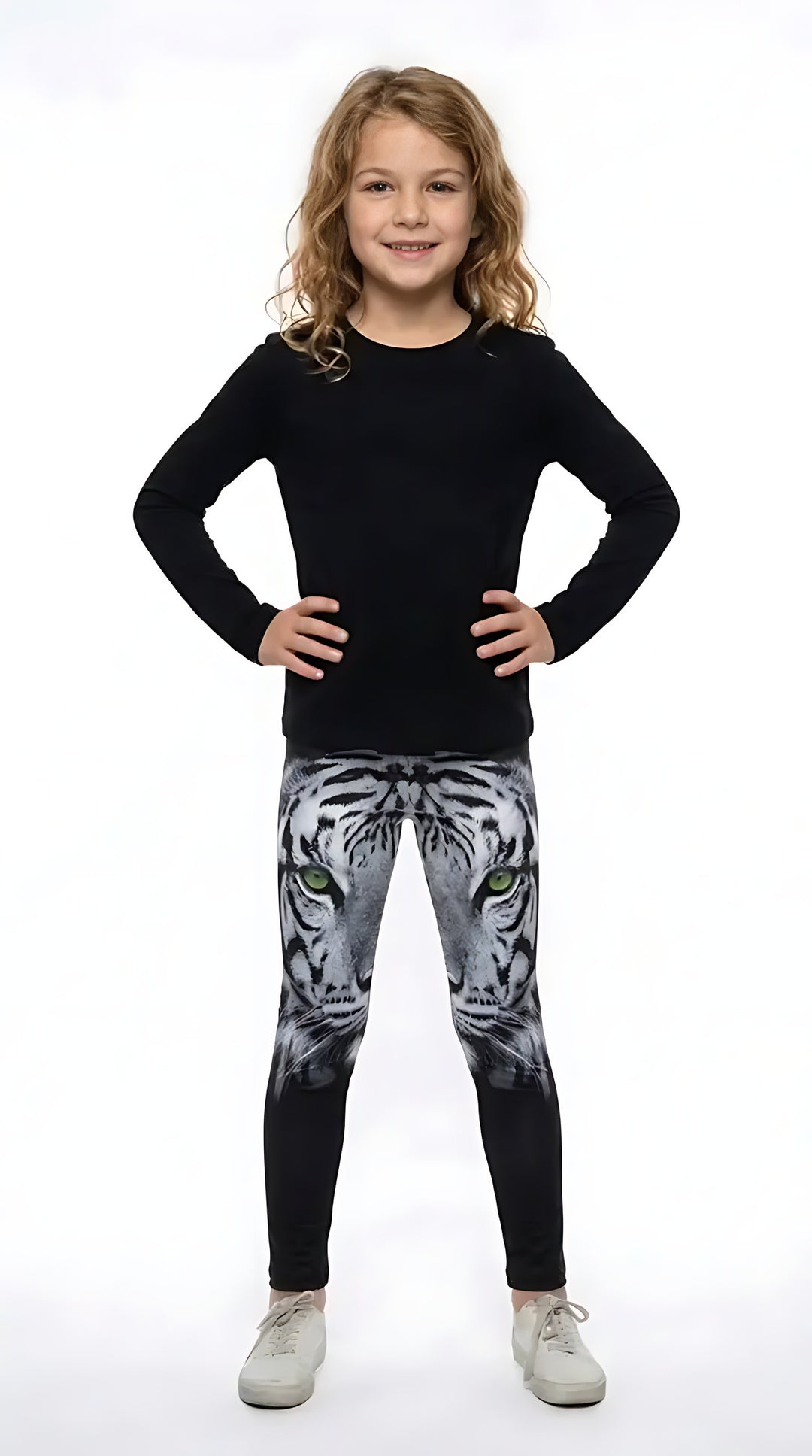 Girl in a black long-sleeve top wearing black girls leggings with a green-eyed white tiger face on the thighs
