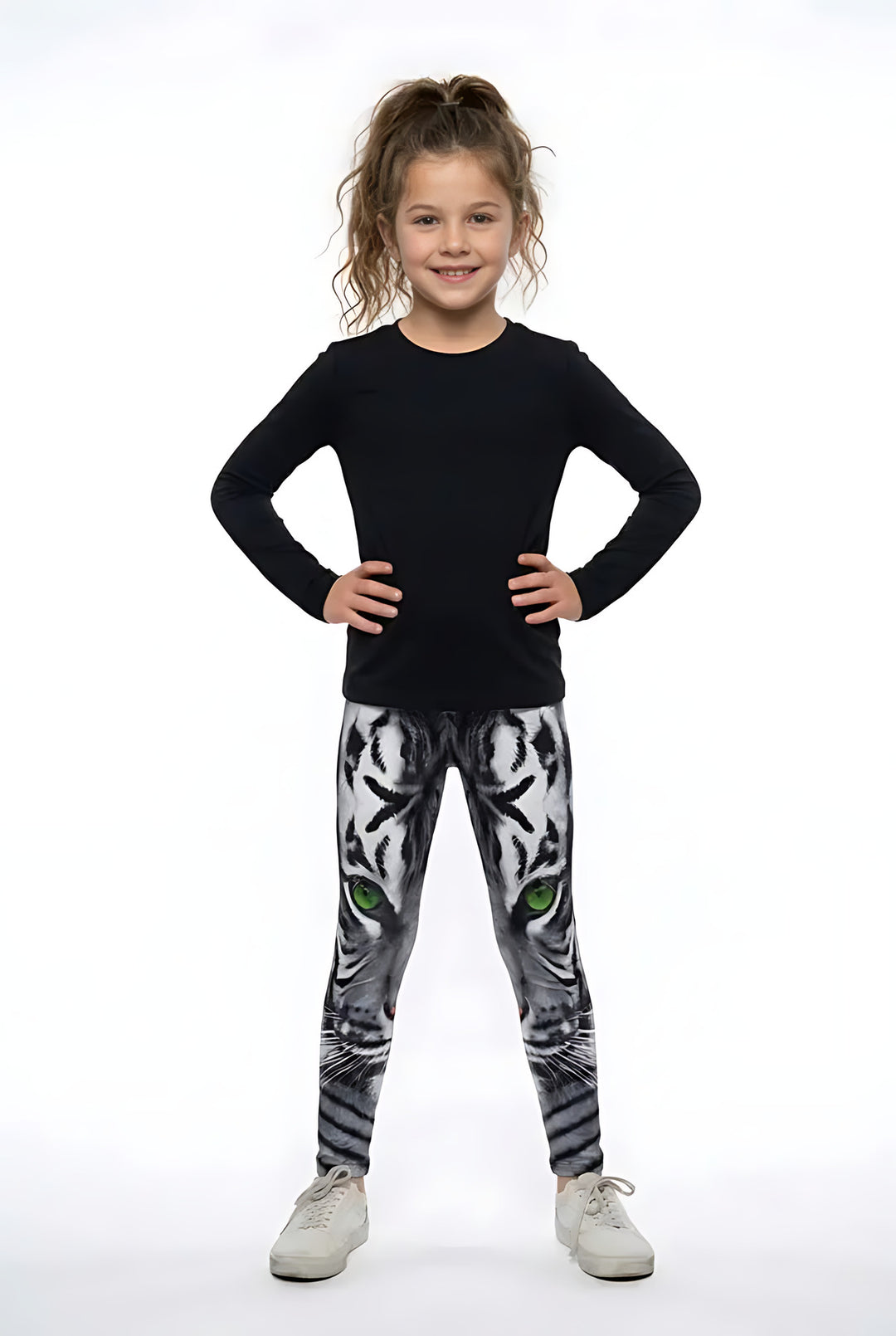 Girl in a black long-sleeve top and white sneakers wearing white tiger print girls leggings with green eyes