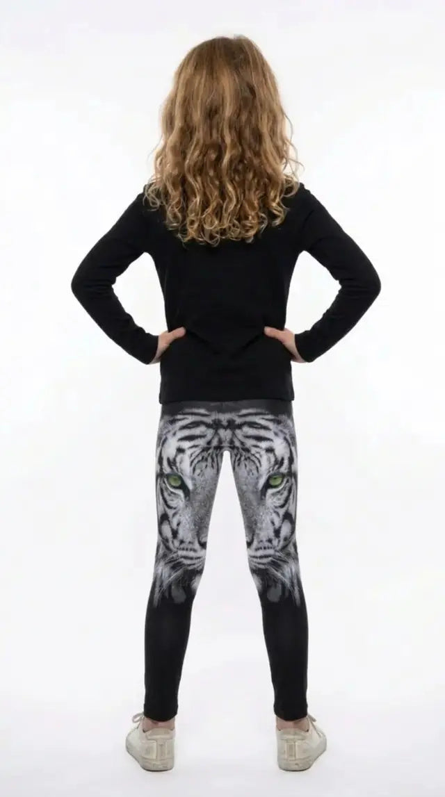 Back view of a girl with long curly hair wearing black girls leggings with a white tiger face on the upper legs
