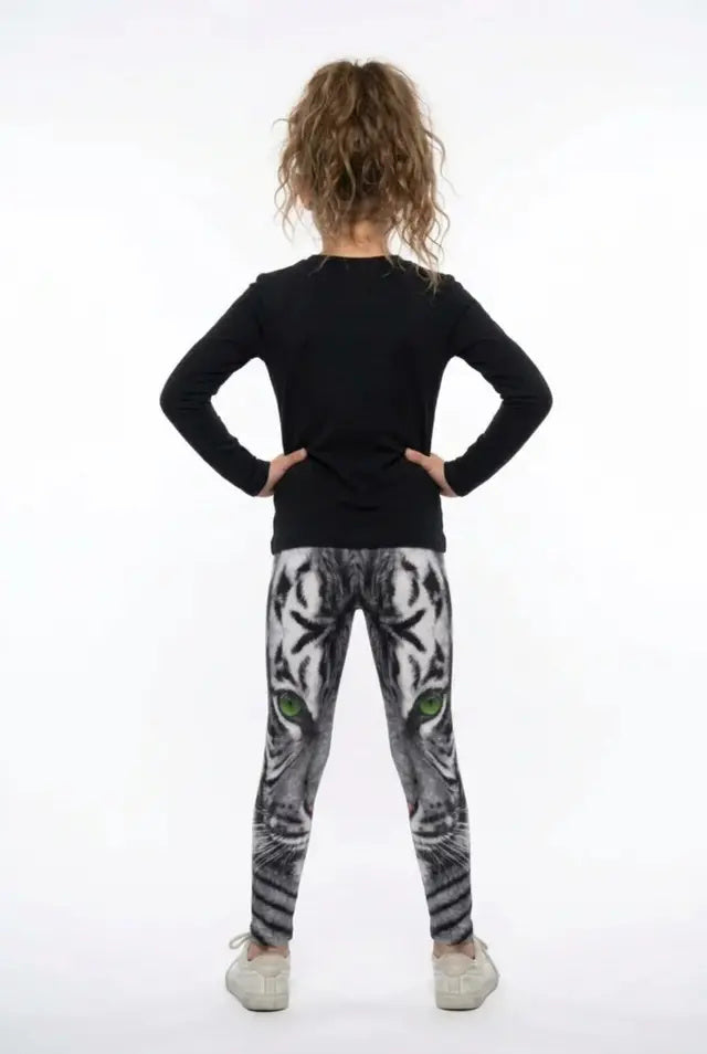 Back view of a girl in a black long-sleeve top wearing all-over white tiger print girls leggings